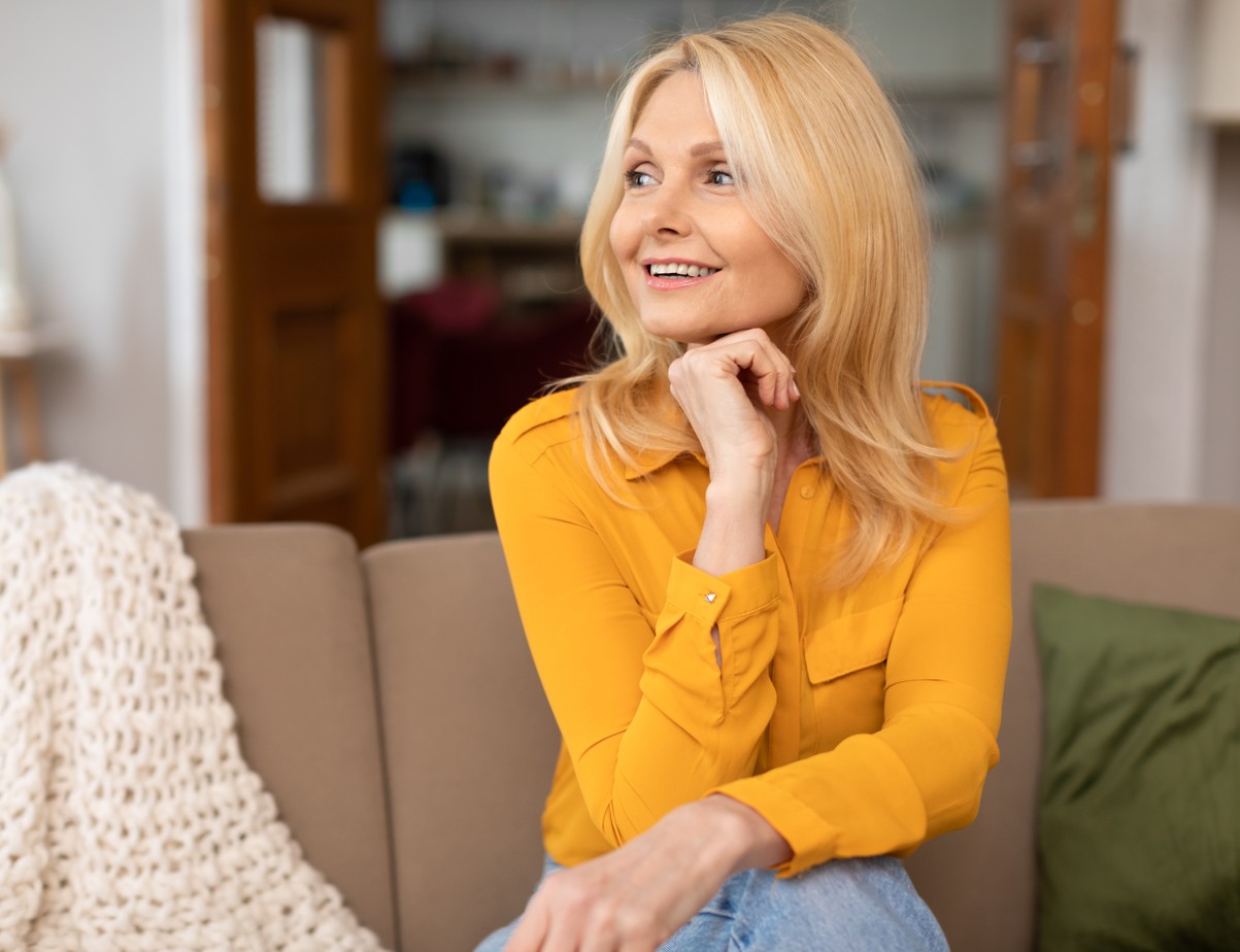 Woman on couch with blanket.