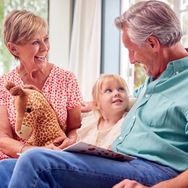 Grandparents reading to their grandaughter.